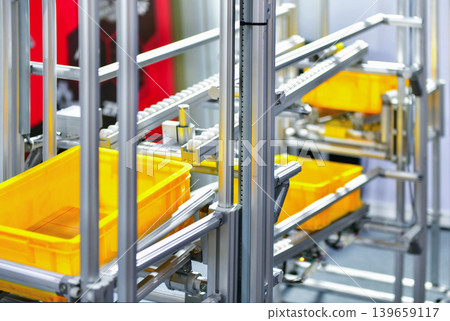 Automated multi layer conveyor system with yellow plastic bins, modern factory logistics and automation. 139659117
