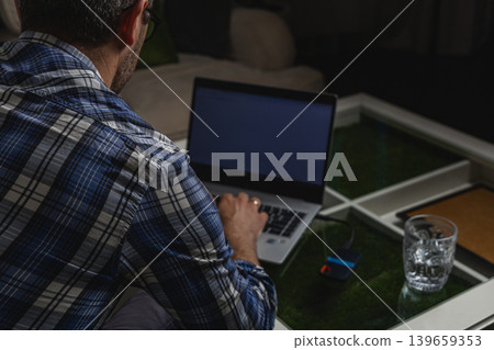 Remote worker browsing internet on laptop from home Remote worker browsing internet on laptop from home 139659353