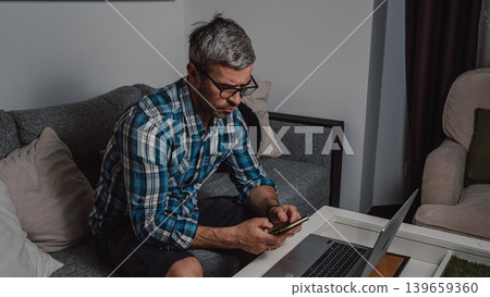 Remote worker using smartphone during overtime Remote worker using smartphone during overtime 139659360