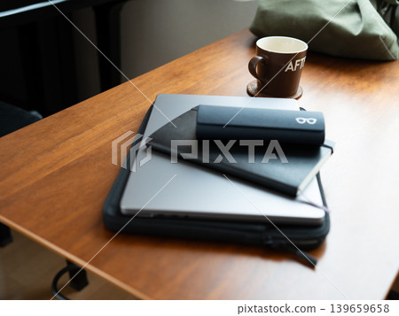 A notebook and glasses case on top of the laptop. 139659658