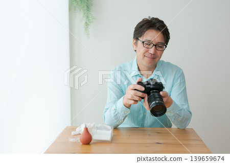A man smiling with a camera in his hand. A man smiling with a camera in his hand. 139659674