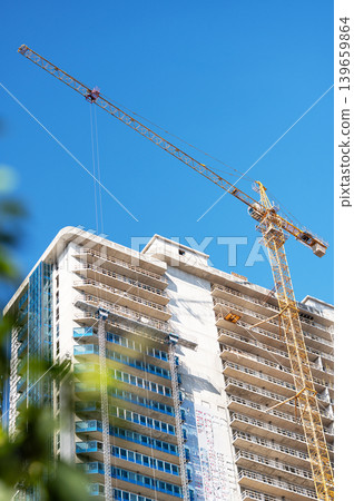 High-rise building under construction with tower crane, urban development and real estate concept 139659864