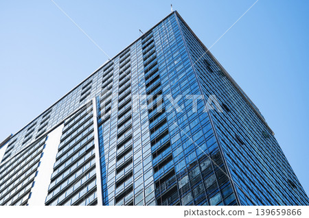 Modern high-rise residential buildings with glass facades against a clear blue sky. 139659866