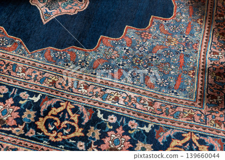 Close-up of a vintage rug corner featuring intricate floral motifs Close-up of a vintage rug corner featuring intricate floral motifs 139660044