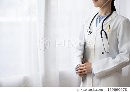 Close-up of the hands of a female doctor wearing a white coat. Close-up of the hands of a female doctor wearing a white coat. 139660078
