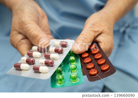 Asian elderly woman holding pill drug in hand, strong healthy medical. Asian elderly woman holding pill drug in hand, strong healthy medical. 139660090