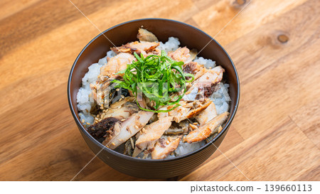 烤鯖魚飯,配上鯖魚絲和紫蘇葉,盛於木桌上。 烤鯖魚飯,配上鯖魚絲和紫蘇葉,盛於木桌上。 139660113