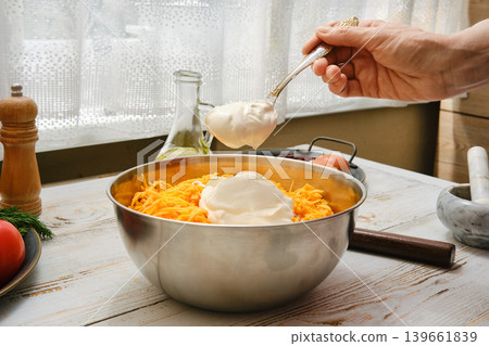 Mixing ingredients in a bowl to prepare a dish in a kitchen setting during daytime Mixing ingredients in a bowl to prepare a dish in a kitchen setting during daytime 139661839