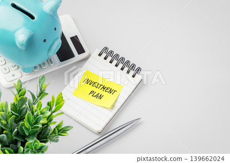 Investmentt plan note with blue piggy bank on calculator on desk, financial strategy, wealth management, and future investment planning 139662024