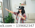 Young child explores virtual reality experience indoors with excitement and curiosity, wearing a VR headset in a cozy and modern living room environment 139662347