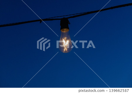 a light bulb burning in the dark 139662587