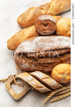Assortment of fresh baked bread on rustic wooden board Assortment of fresh baked bread on rustic wooden board 139662907