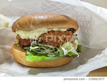 A crispy shrimp cutlet burger topped with plenty of tartar sauce. A crispy shrimp cutlet burger topped with plenty of tartar sauce. 139662977