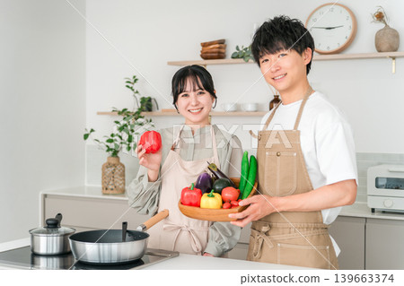 Young Asian man and woman holding vegetables in the kitchen, couple, husband and wife Young Asian man and woman holding vegetables in the kitchen, couple, husband and wife 139663374