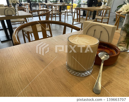 a cup of coffee with a spoon on a table a cup of coffee with a spoon on a table 139663707