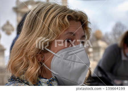 Adult woman wearing a medical mask to protect against coronavirus infection. Adult woman wearing a medical mask to protect against coronavirus infection. 139664199