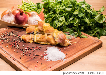 raw chicken skewers marinated with lemon on a wooden board raw chicken skewers marinated with lemon on a wooden board 139664340