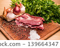 Raw pork meat with garlic, onions, parsley and spices on wooden board 139664347