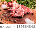 Raw lamb chops with garlic, onions, parsley and spices on wooden board 139664348
