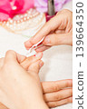 The esthetician removes the old nail polish with a cotton and remover 139664350