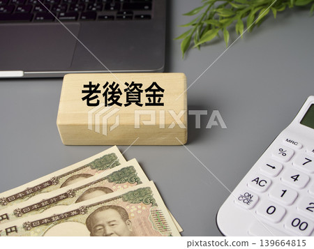 A financial image featuring wooden blocks, a calculator, and banknotes, representing retirement funds, against a gray background. 139664815