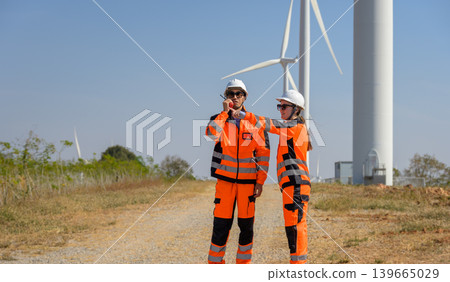 Wind energy engineers conducting site inspection at wind farm facility 139665029