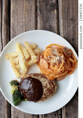 A plate of hamburger steak with demi-glace sauce, potatoes, and Neapolitan spaghetti. 139665356