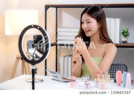 Young asian woman presenting and review cosmetic product with on social media. Young asian woman presenting and review cosmetic product with on social media. 139665387