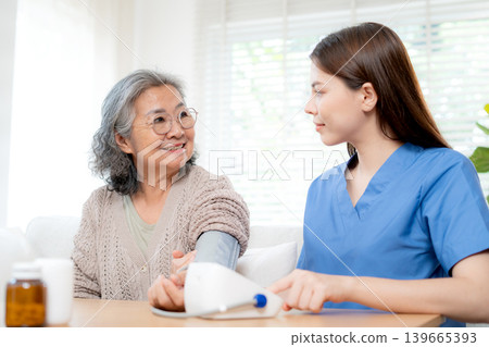 Asian woman nurse measuring blood pressure senior patient. Asian woman nurse measuring blood pressure senior patient. 139665393
