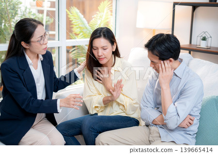 Asian couple arguing with therapist during home consultation. Asian couple arguing with therapist during home consultation. 139665414