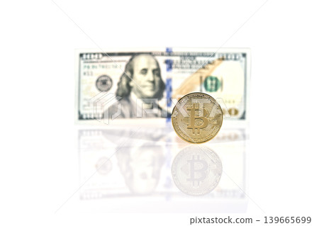 Gold bitcoin coin standing in front of dollar bills Gold bitcoin coin standing in front of dollar bills 139665699