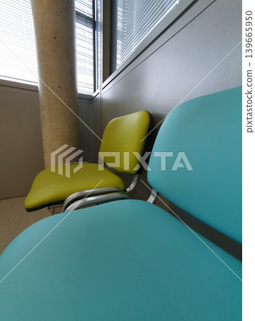 Phone photo of blue and green chairs in a hospital waiting area. Calm and organized interior scene showing seating, healthcare environment, and functional design. Phone photo of blue and green chairs in a hospital waiting area. Calm and organized interior scene showing seating, healthcare environment, and functional design. 139665950