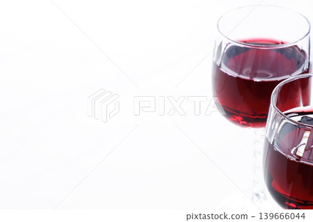 Toasting with red wine - Image of two wine glasses filled with red wine making a toast Toasting with red wine - Image of two wine glasses filled with red wine making a toast 139666044