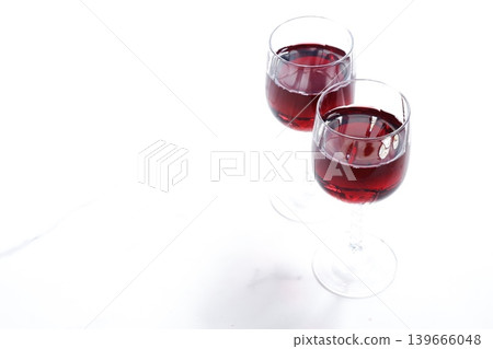 Toasting with red wine - Image of two wine glasses filled with red wine making a toast Toasting with red wine - Image of two wine glasses filled with red wine making a toast 139666048