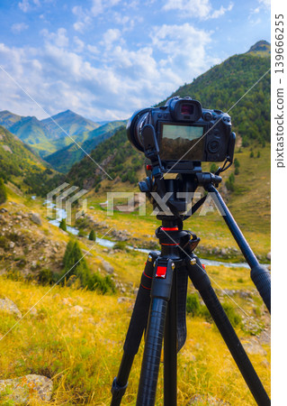 Camera on Tripod Capturing Scenic Mountain Valley Landscape, focus on camera Camera on Tripod Capturing Scenic Mountain Valley Landscape, focus on camera 139666255