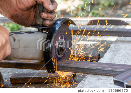 Close-up of angle grinder cutting metal bars outdoors Close-up of angle grinder cutting metal bars outdoors 139666270