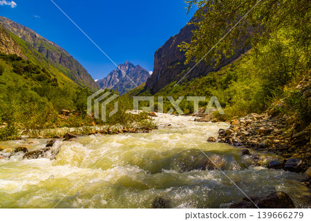 Mountain valley with fast-flowing river and craggy mountains 139666279