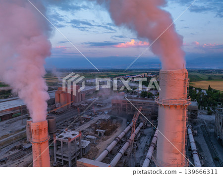 Industrial smokestacks emitting pink smoke at dusk 139666311
