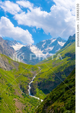 Majestic snow-capped mountains over lush valley with waterfall Majestic snow-capped mountains over lush valley with waterfall 139666330