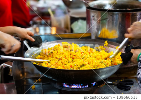 Close-up of cooking traditional Vietnamese rice meal in a large wok in Ho Chi Minh City, Vietnam. Close-up of cooking traditional Vietnamese rice meal in a large wok in Ho Chi Minh City, Vietnam. 139666513