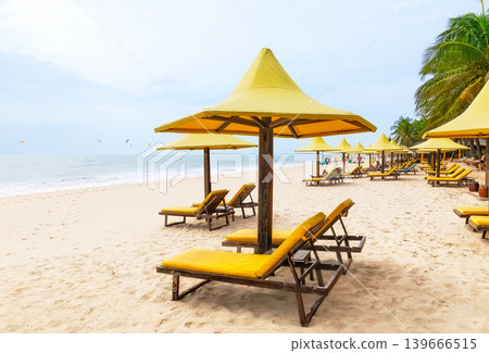 Beautiful sandy beach with lounge chairs and umbrellas on Mui Ne coast in Vietnam. Beautiful sandy beach with lounge chairs and umbrellas on Mui Ne coast in Vietnam. 139666515