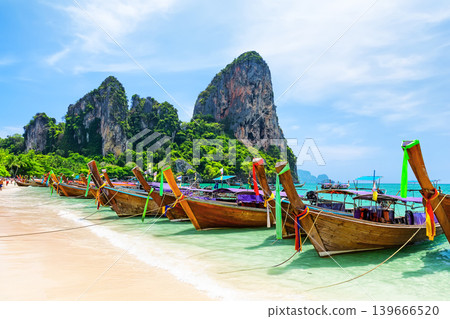 Longtail Boats on amazing Railay Beach in Krabi province. Ao Nang, Thailand. Scenic Railay Beach with traditional boats, turquoise water and limestone cliffs in Krabi, Thailand Longtail Boats on amazing Railay Beach in Krabi province. Ao Nang, Thailand. Scenic Railay Beach with traditional boats, turquoise water and limestone cliffs in Krabi, Thailand 139666520