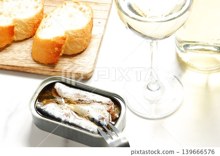 Canned oil sardines, freshly baked baguette, and a glass of white wine. Canned oil sardines, freshly baked baguette, and a glass of white wine. 139666576