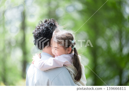A smiling little girl hugs her father in a park surrounded by fresh greenery. A picture of parent-child love and happy family time. "I love you, Daddy!" Perfect for Father's Day and other special occasions. A smiling little girl hugs her father in a park surrounded by fresh greenery. A picture of parent-child love and happy family time. "I love you, Daddy!" Perfect for Father's Day and other special occasions. 139666811