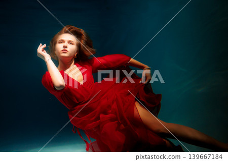 Underwater themed fashion shoot featuring poised reddressed woman Underwater themed fashion shoot featuring poised reddressed woman 139667184