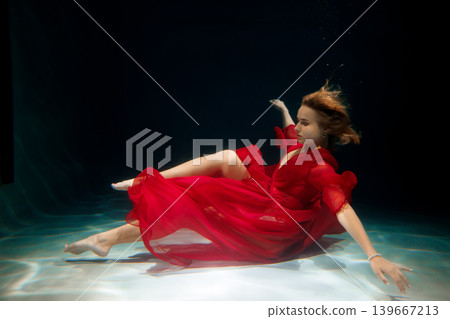 High fashion model in vibrant dress under artistic lighting effects 139667213