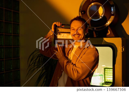 Artistic individual displaying vintage audio devices confidently Artistic individual displaying vintage audio devices confidently 139667306