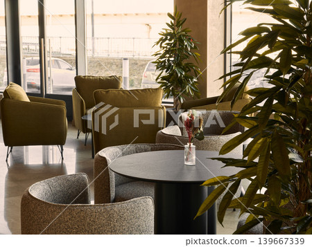 Modern indoor cafe featuring textured chairs and warm illumination Modern indoor cafe featuring textured chairs and warm illumination 139667339