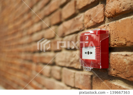 Alarm on brick. Closeup of red fire alarm on aged brick wall Alarm on brick. Closeup of red fire alarm on aged brick wall 139667363