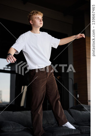 Stylish male posing comfortably in contemporary apartment setting Stylish male posing comfortably in contemporary apartment setting 139667465